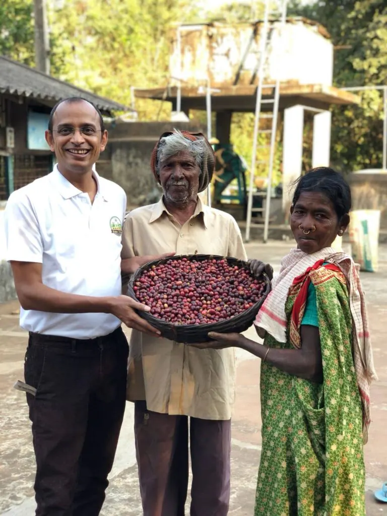 Tribal farmers holding freshly picked coffee cherries